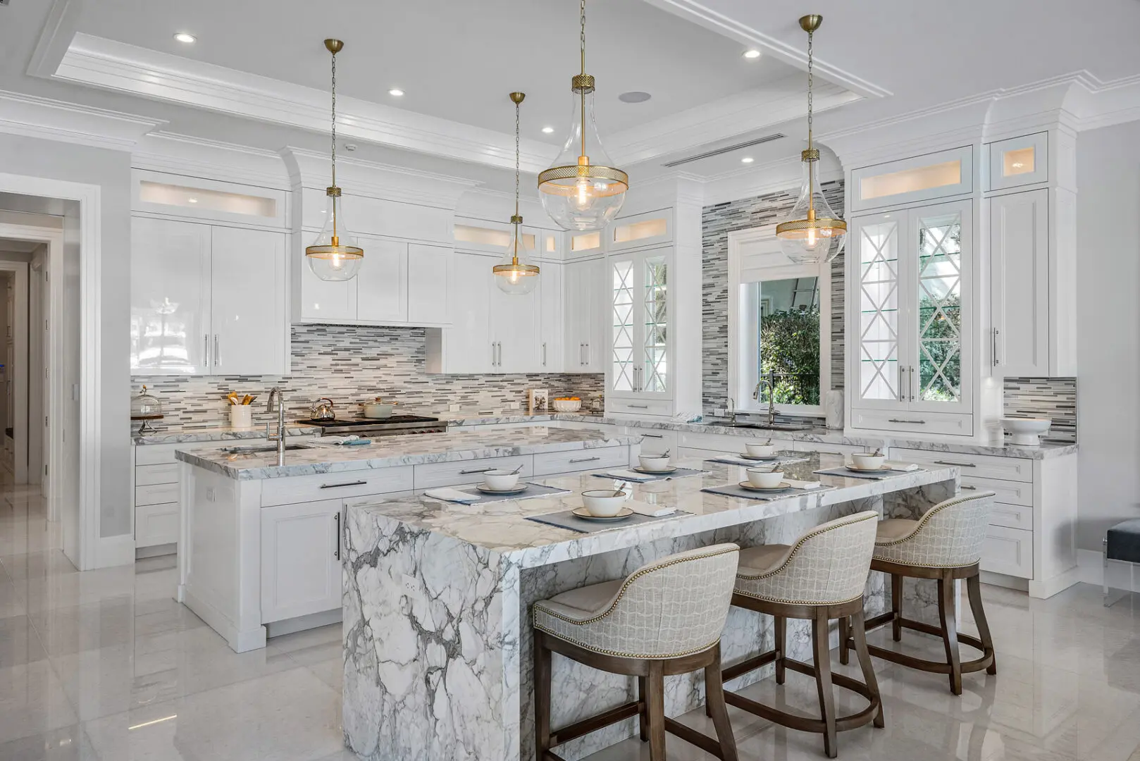 A large kitchen with marble counter tops and white cabinets.