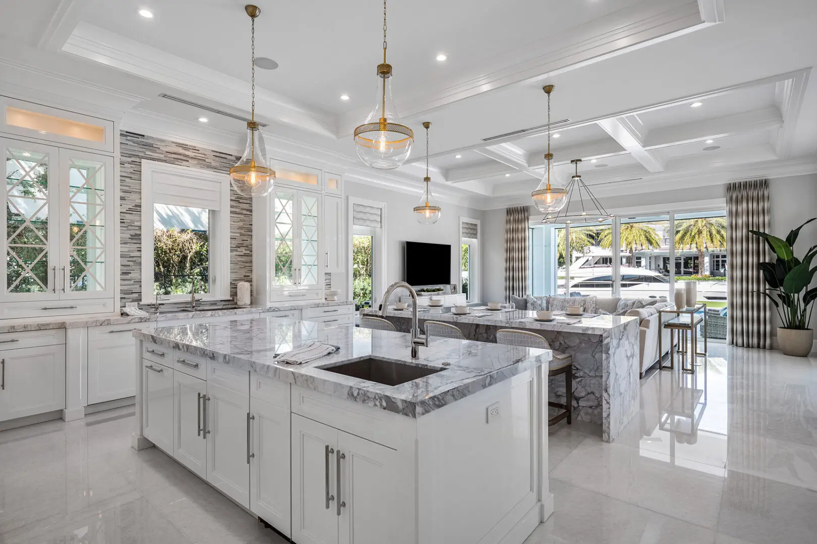 A large kitchen with white cabinets and marble countertops.