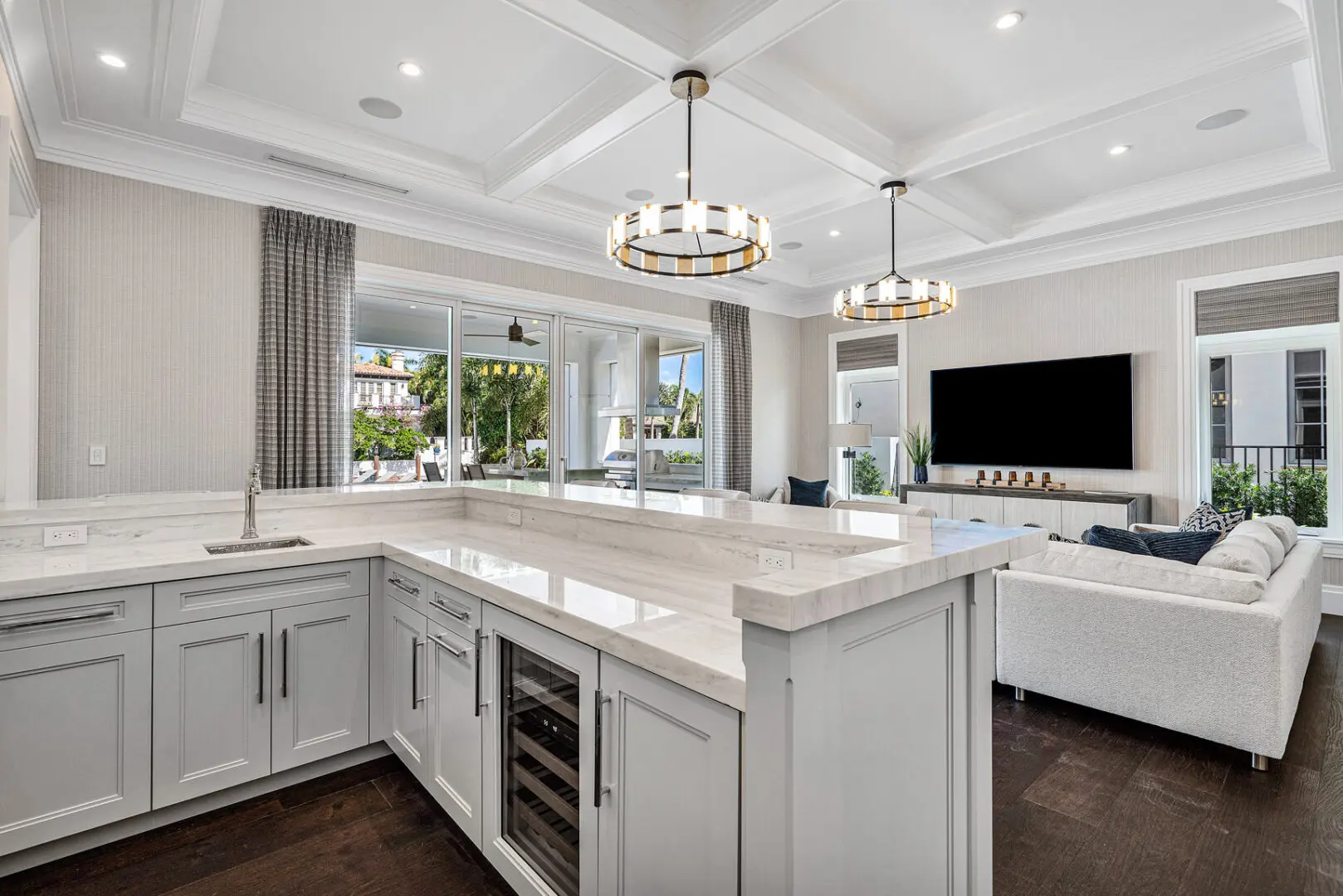 A large kitchen with white cabinets and a bar.