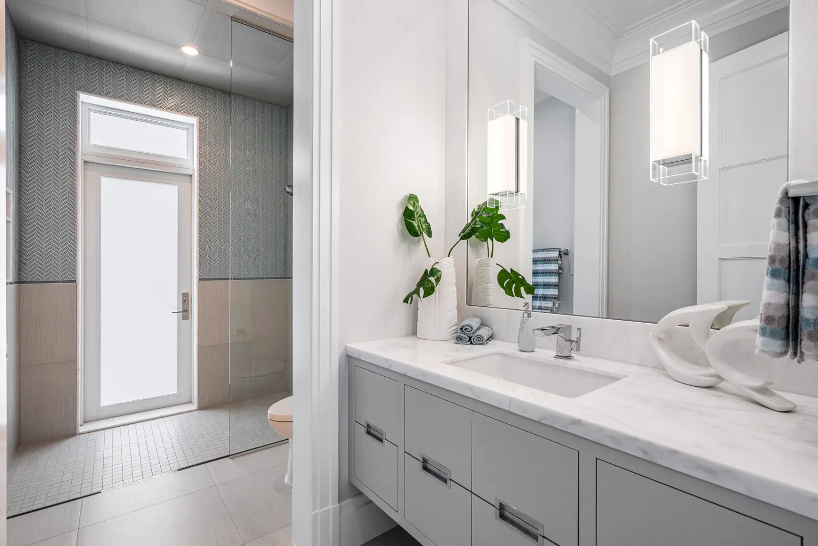 A bathroom with a large mirror and white counter.
