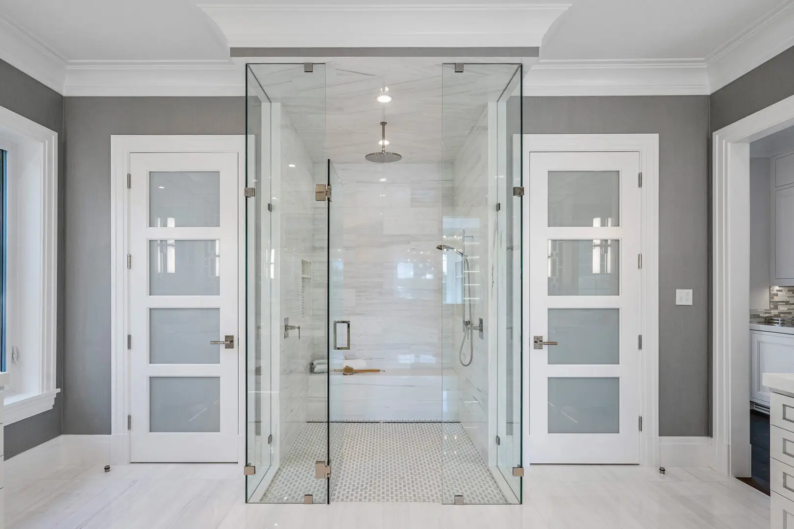A bathroom with two doors and a shower