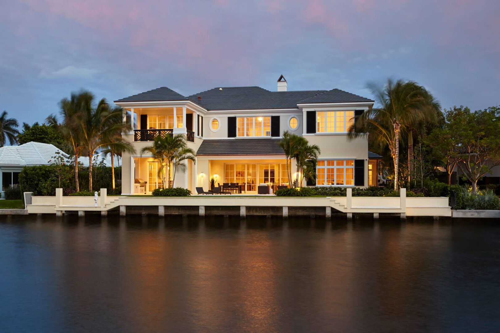 A large white house sitting on the water.