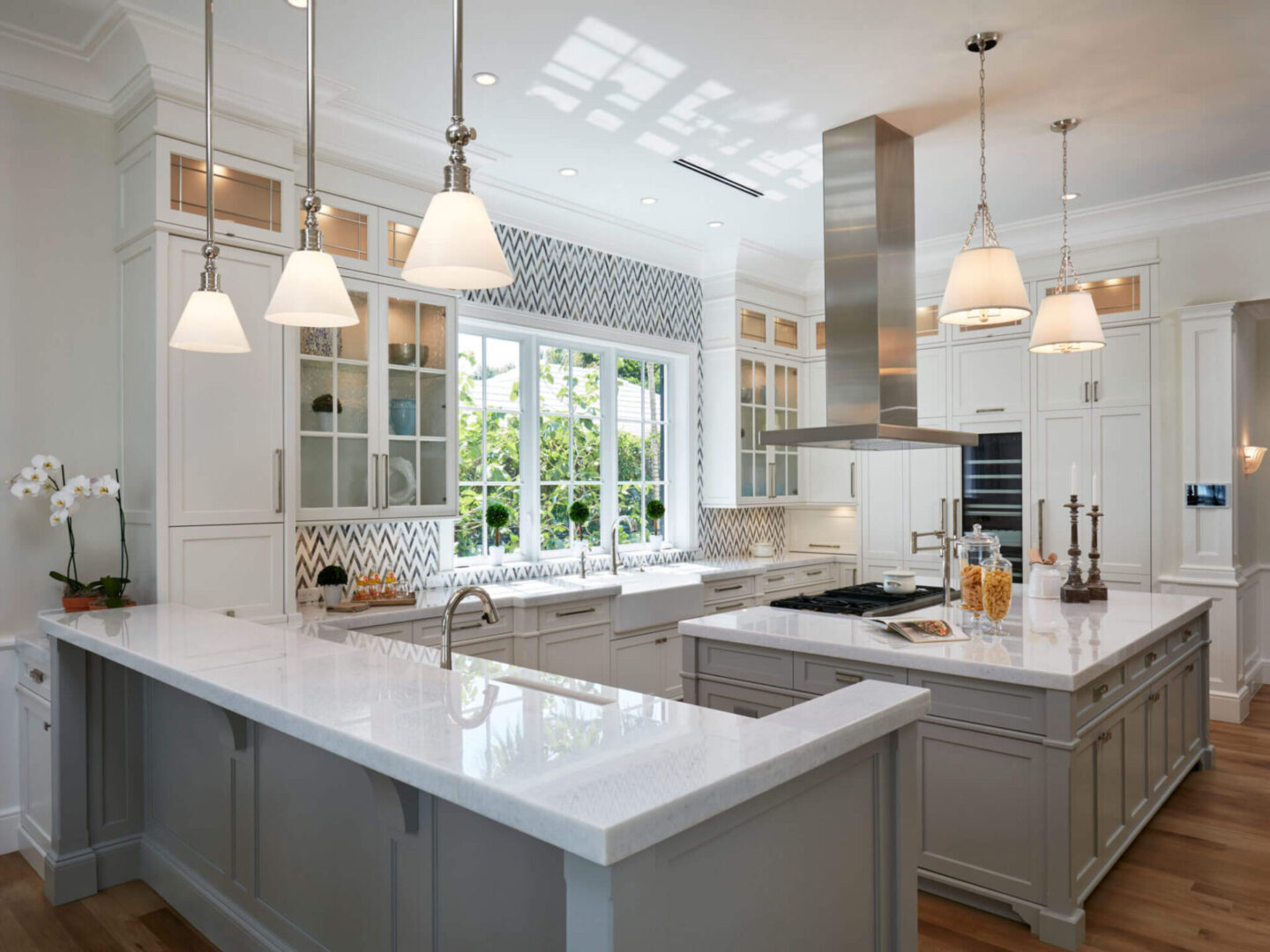 A kitchen with two large windows and white counters.