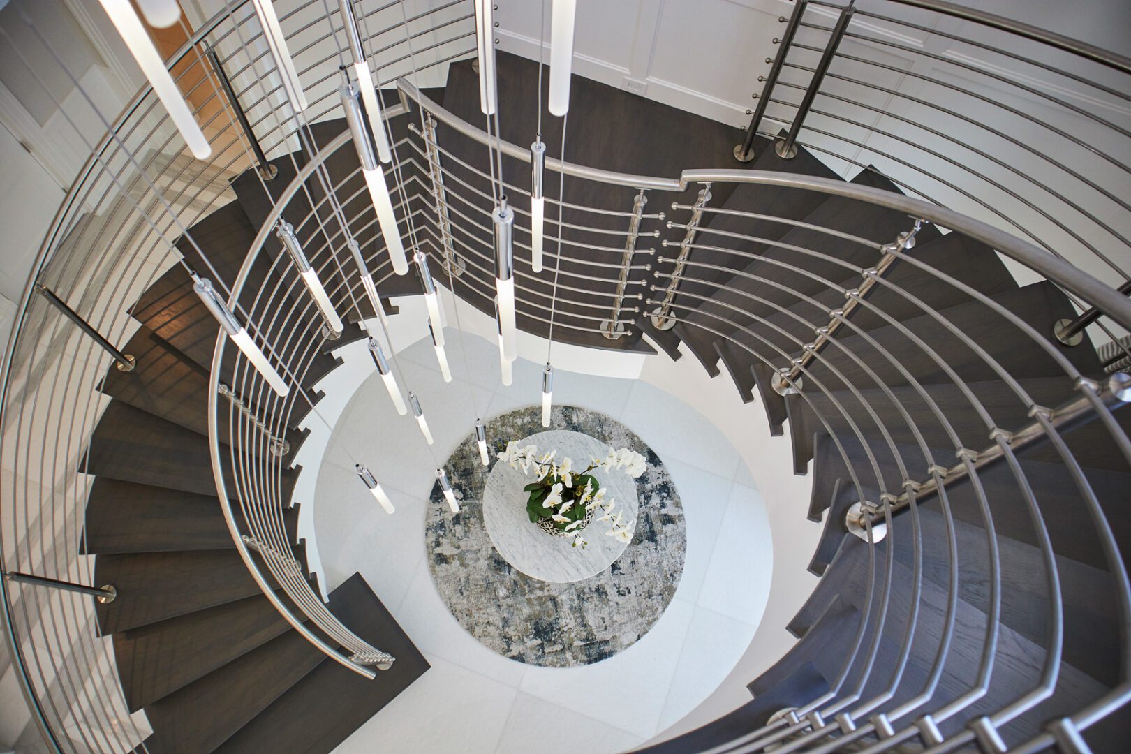 A spiral staircase with metal railing and white walls.