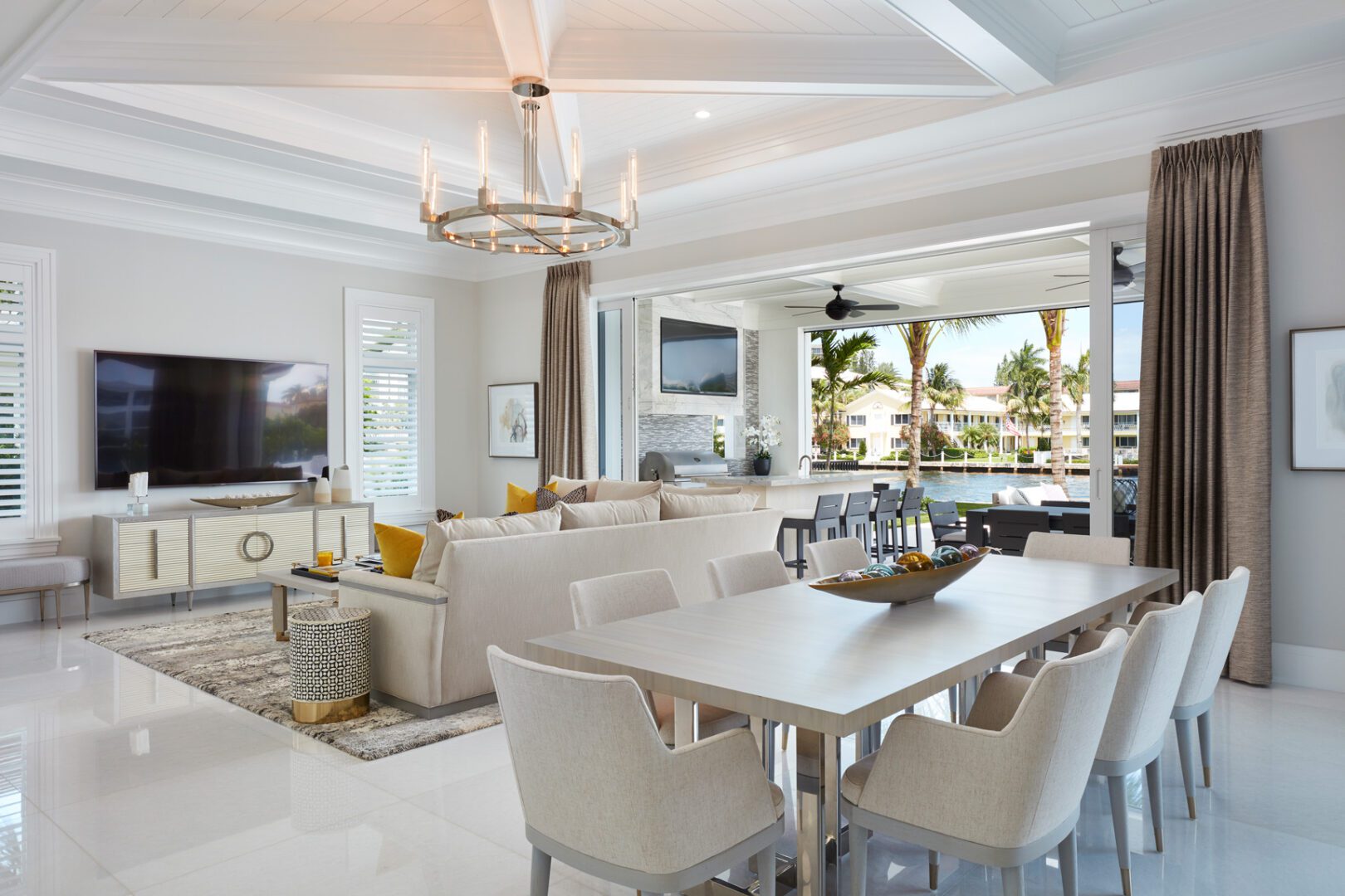 A living room with white furniture and a large open floor plan.
