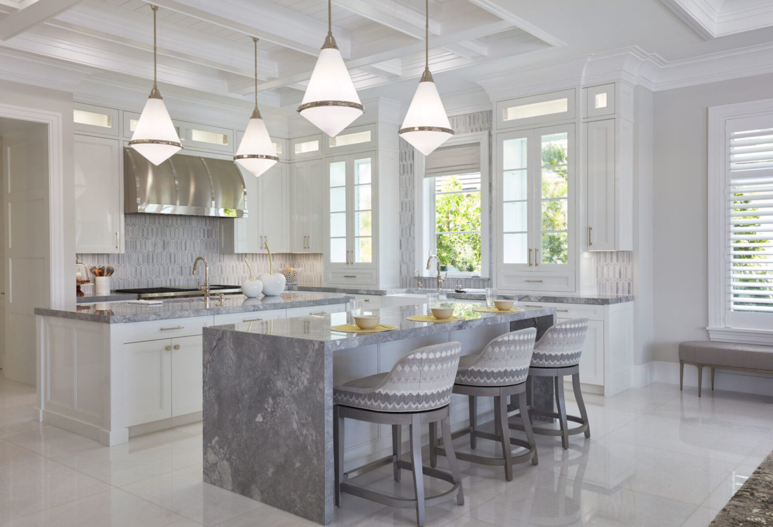 A kitchen with marble counter tops and white walls.