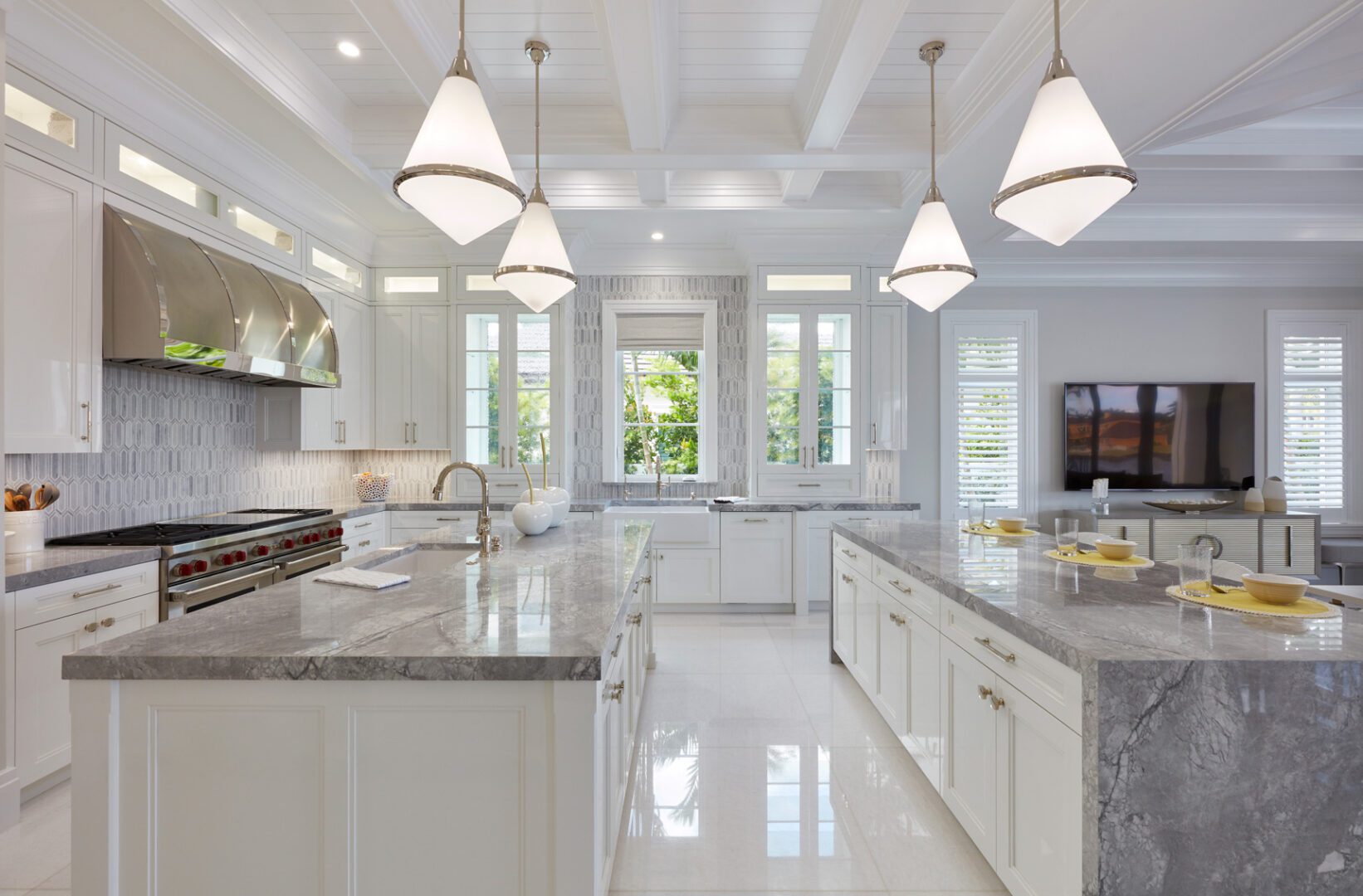 A large kitchen with white cabinets and marble countertops.