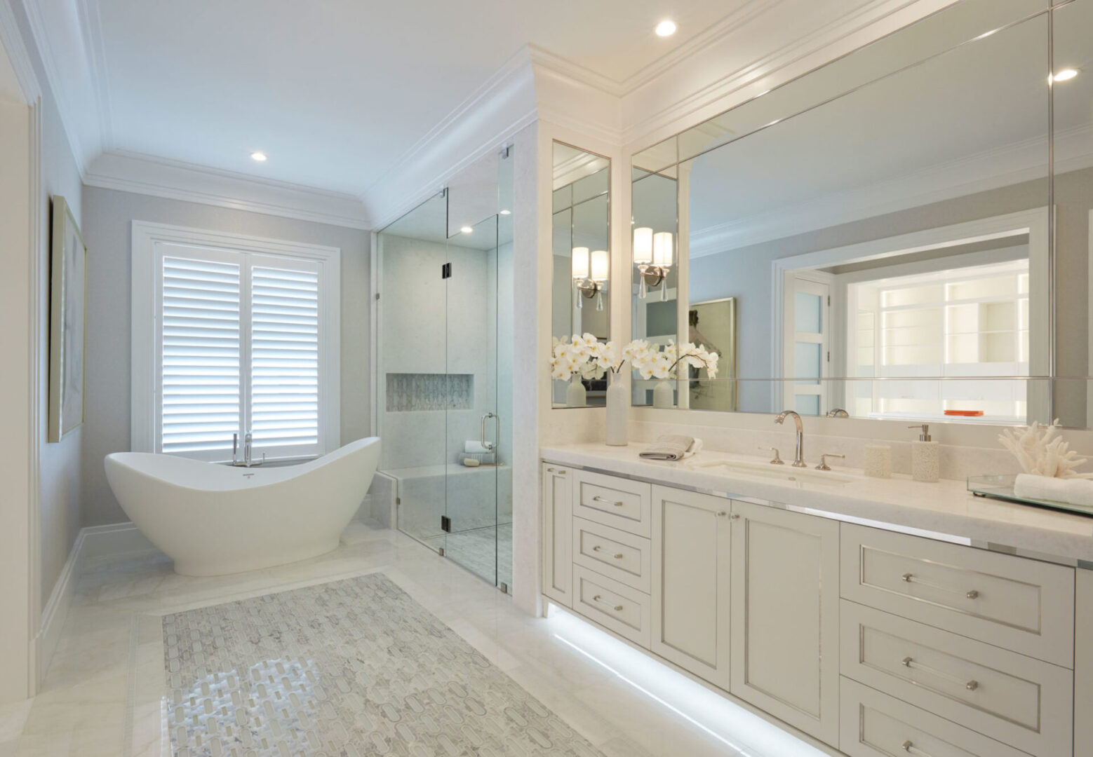 A bathroom with white cabinets and a tub