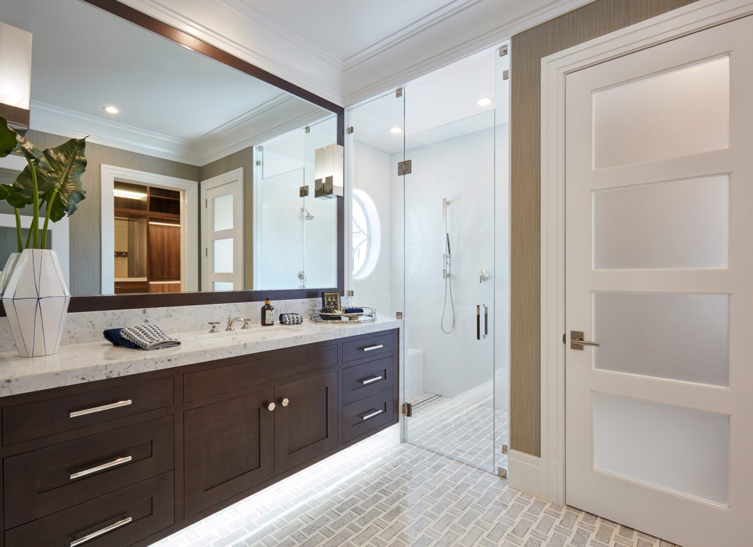 A bathroom with a large mirror and a white tile floor.