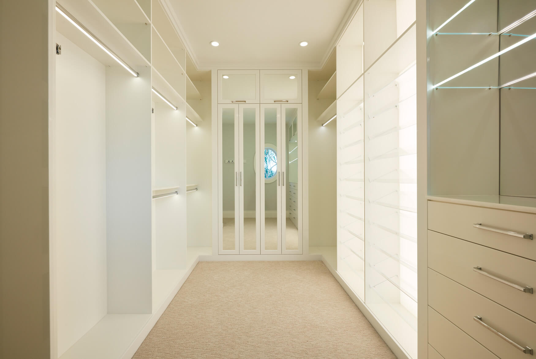 A walk in closet with many glass doors and shelves.