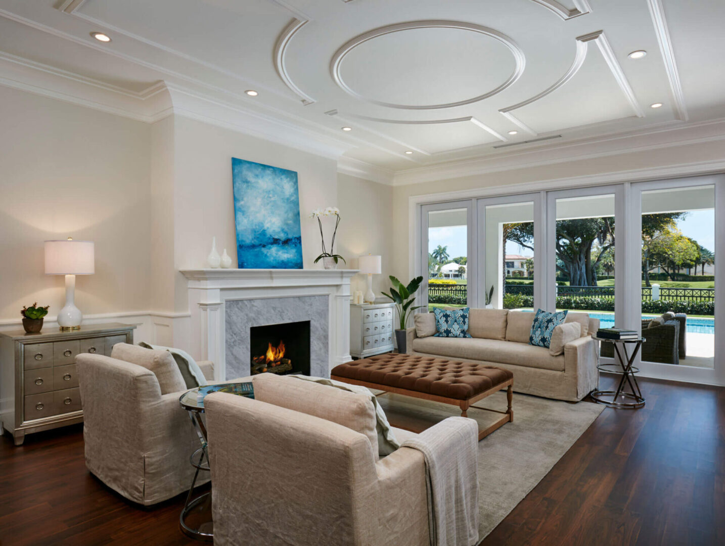 A living room with white furniture and a fireplace.