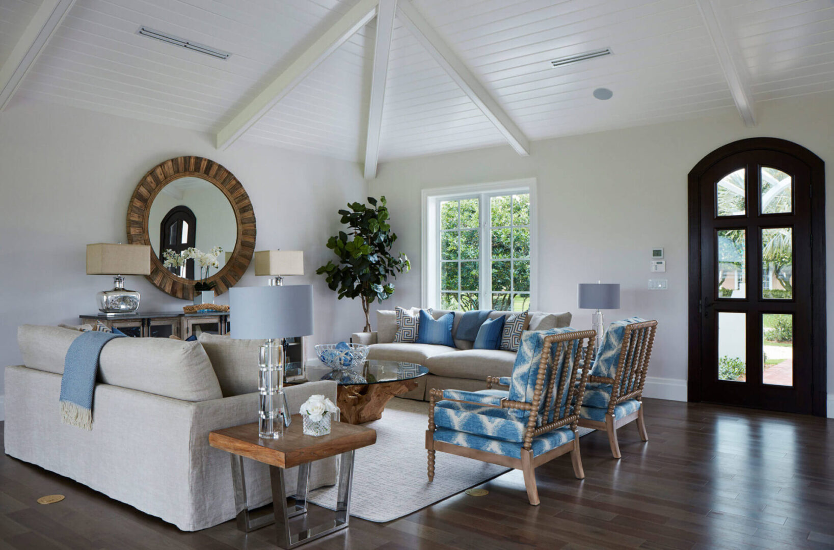 A living room with white furniture and blue accents.