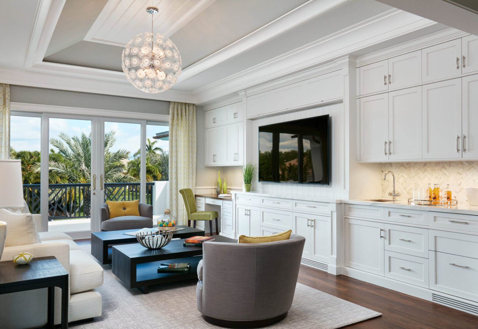 A living room with white furniture and a large flat screen tv.