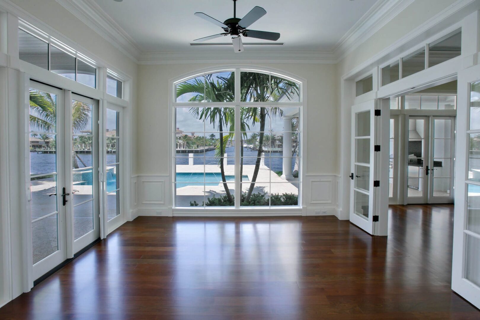 A room with a large window and a pool in the background.
