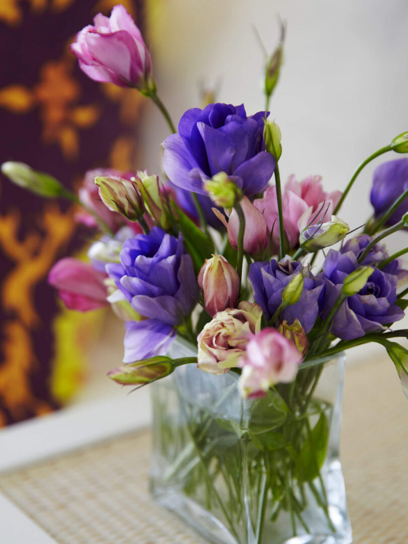 A vase filled with purple flowers on top of a table.