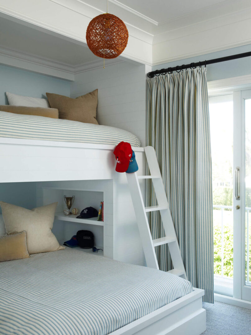 A white bunk bed with ladder and stuffed animal.
