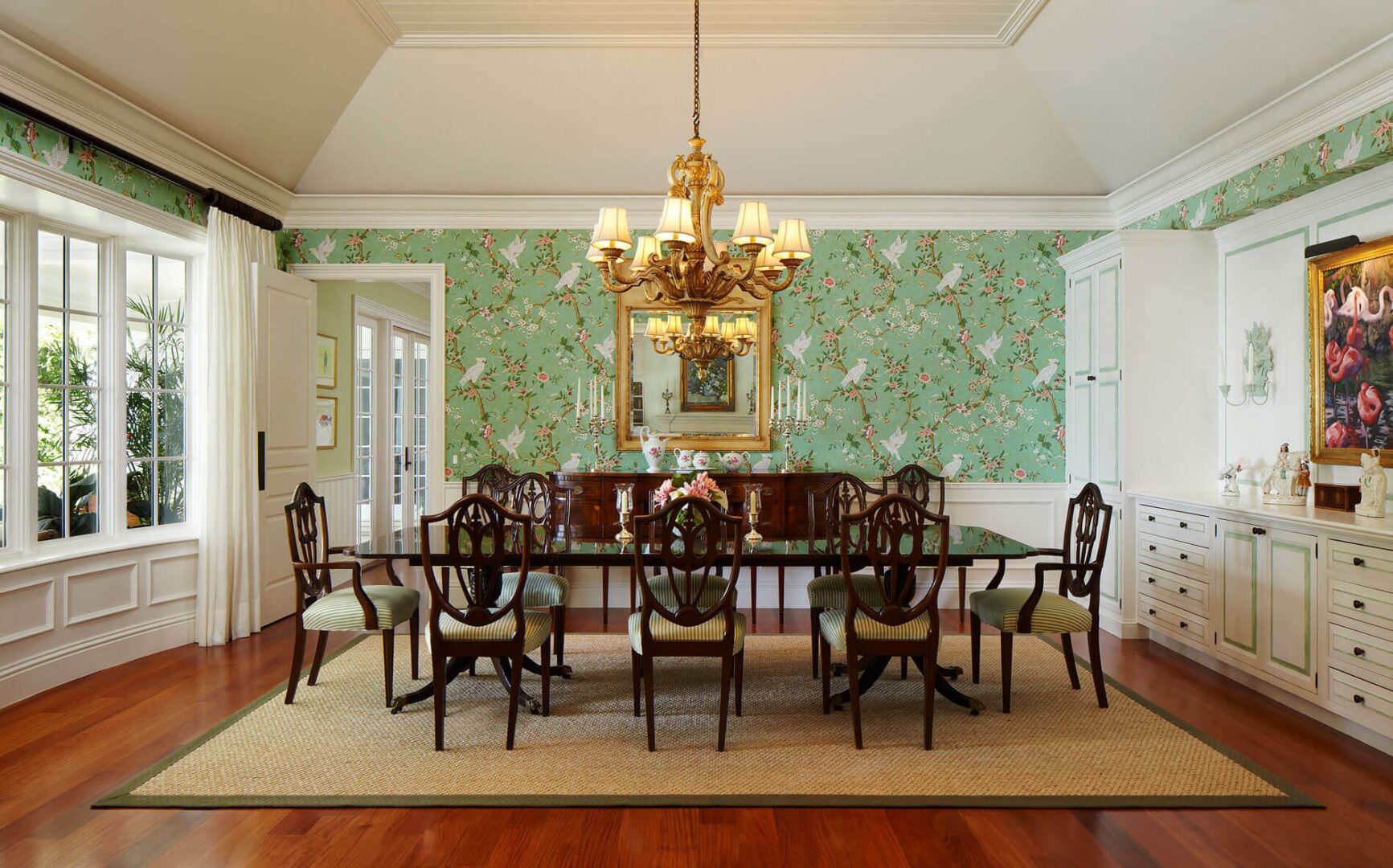 A large dining room table with chairs and a chandelier.