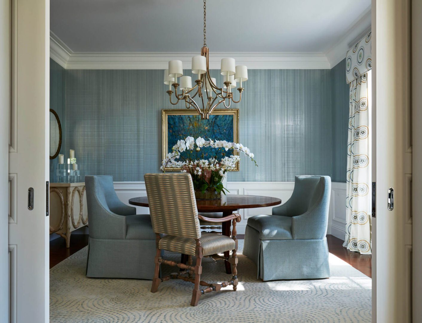 A dining room with blue walls and furniture.