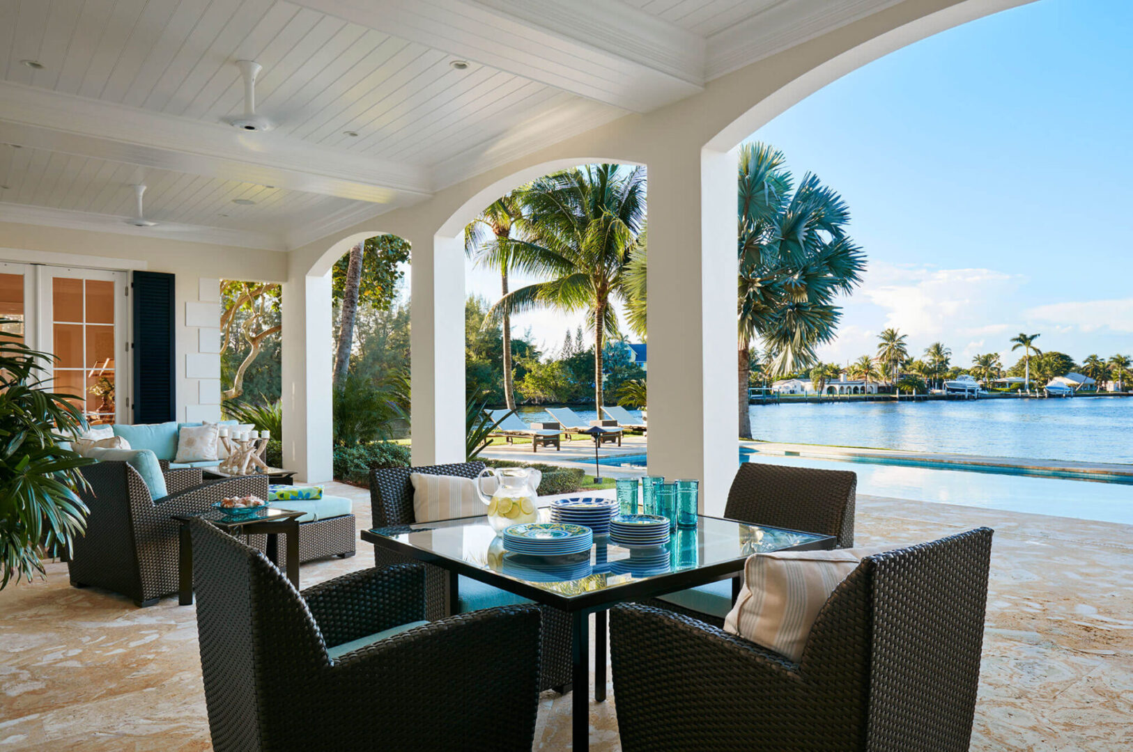 A patio with tables and chairs overlooking the water.