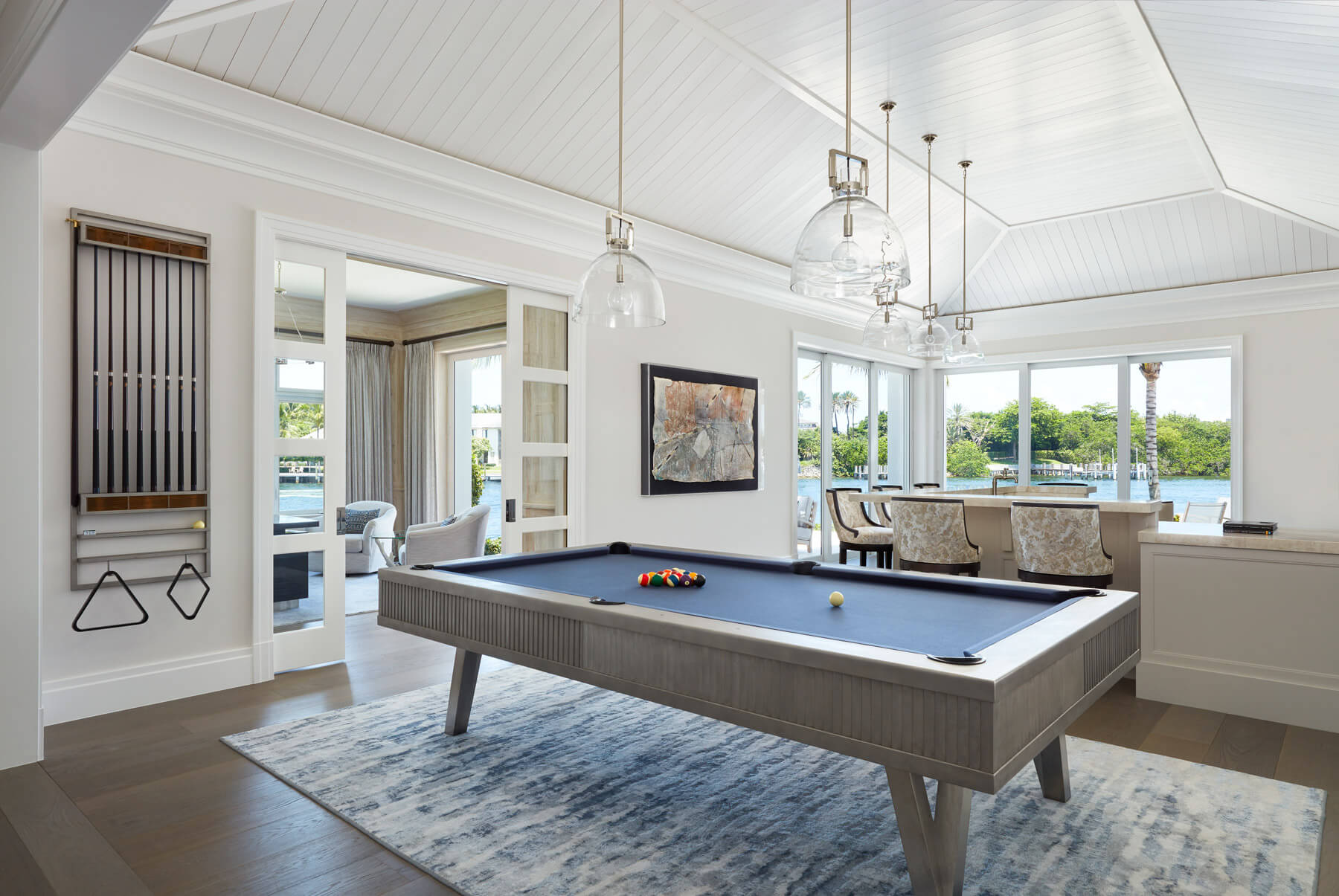 A pool table in the middle of a room with a large rug.
