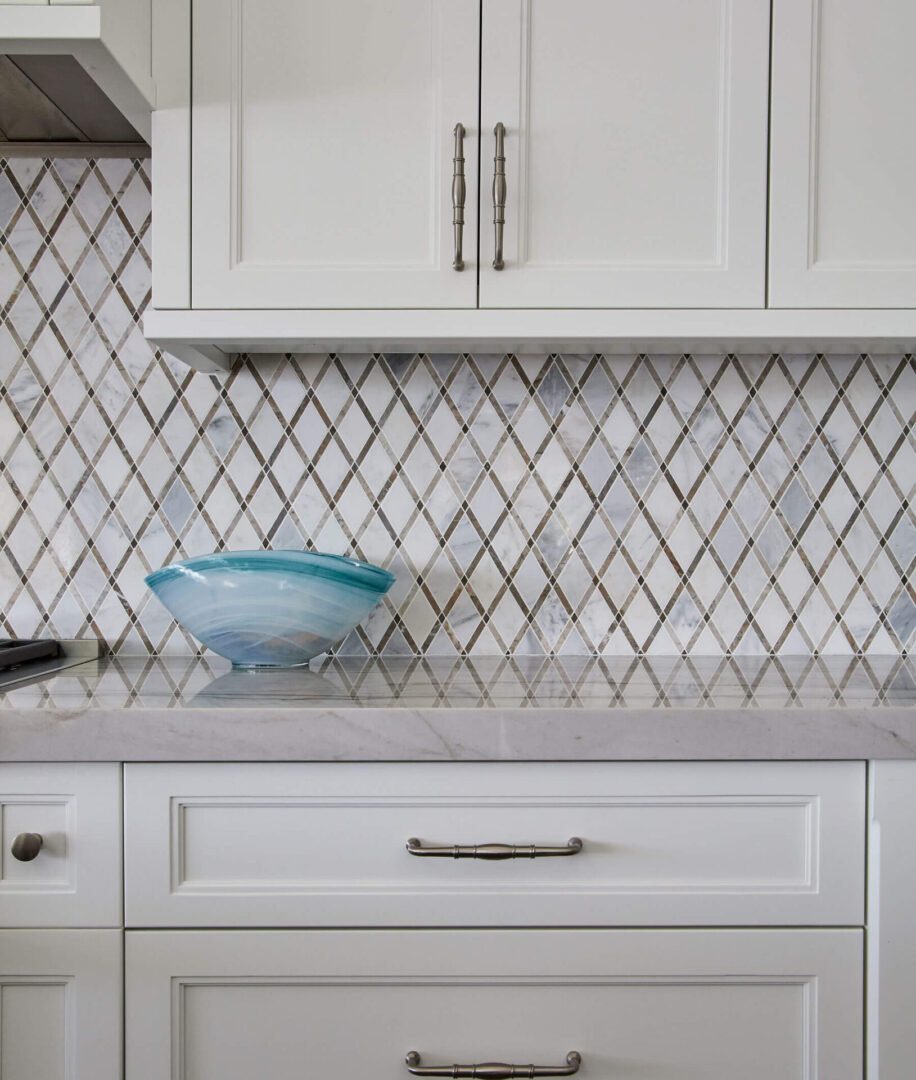 A bowl sits on the counter in front of a tile backsplash.