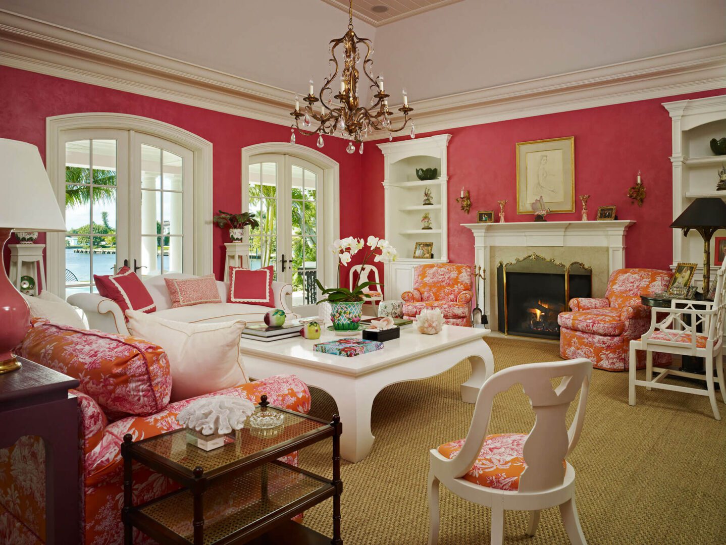 A living room with red walls and white furniture.