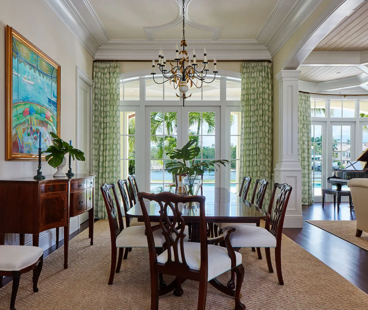 A dining room with a table and chairs, and a chandelier.