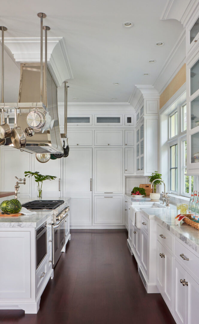 A kitchen with white cabinets and wooden floors