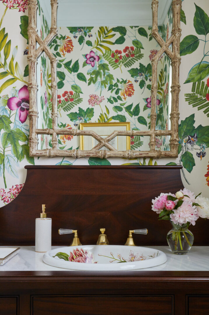 A bathroom with floral wallpaper and a sink.