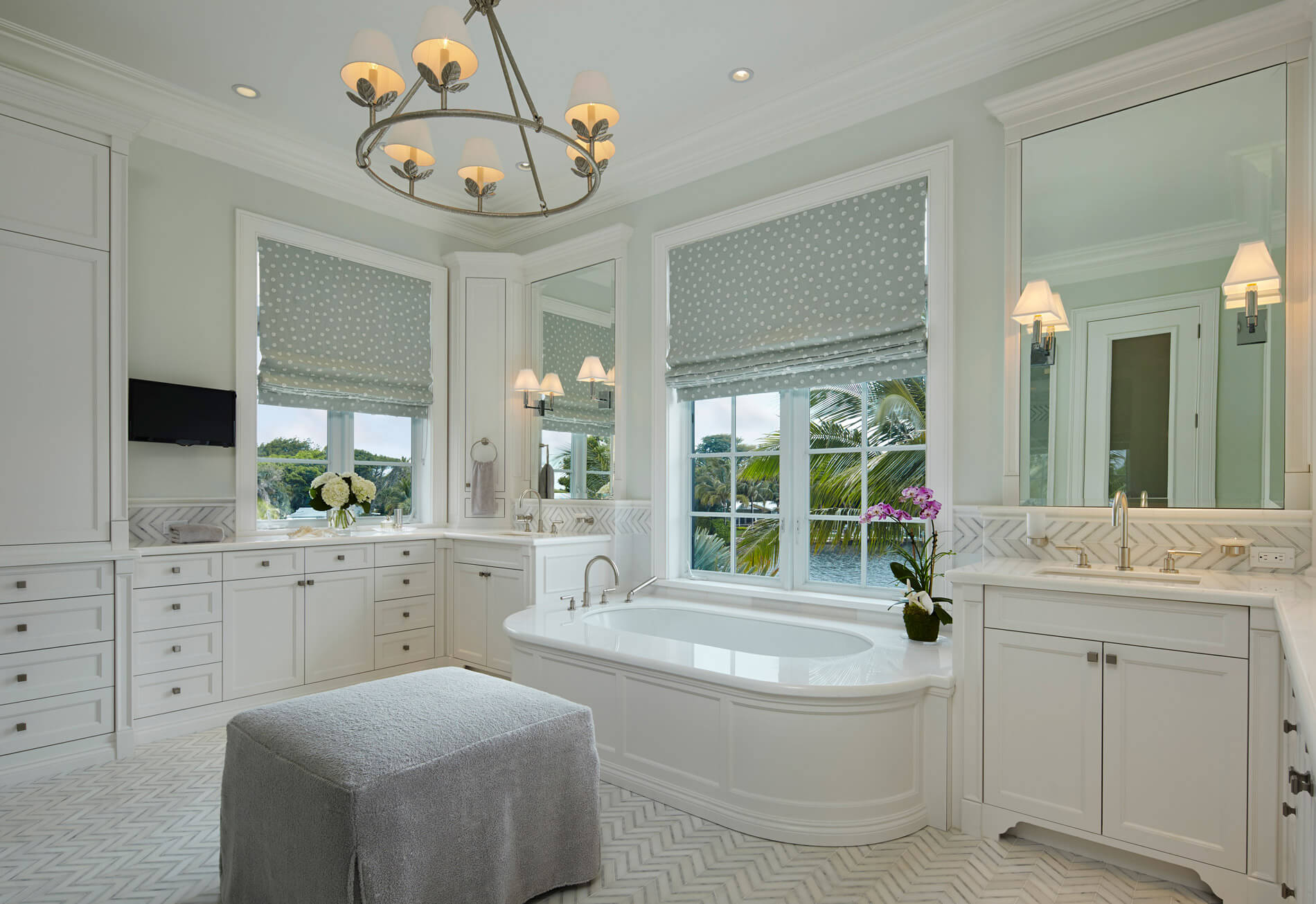 A bathroom with a large tub and white cabinets.