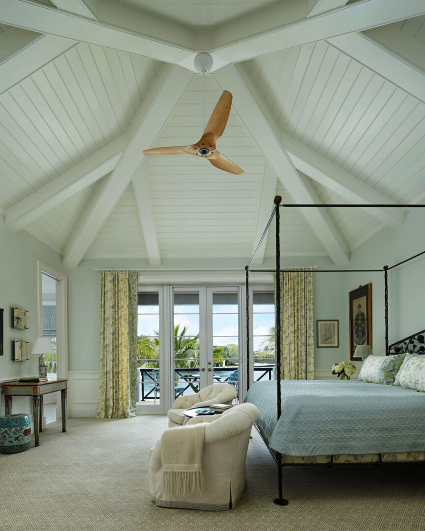 A bedroom with a large bed and a ceiling fan.