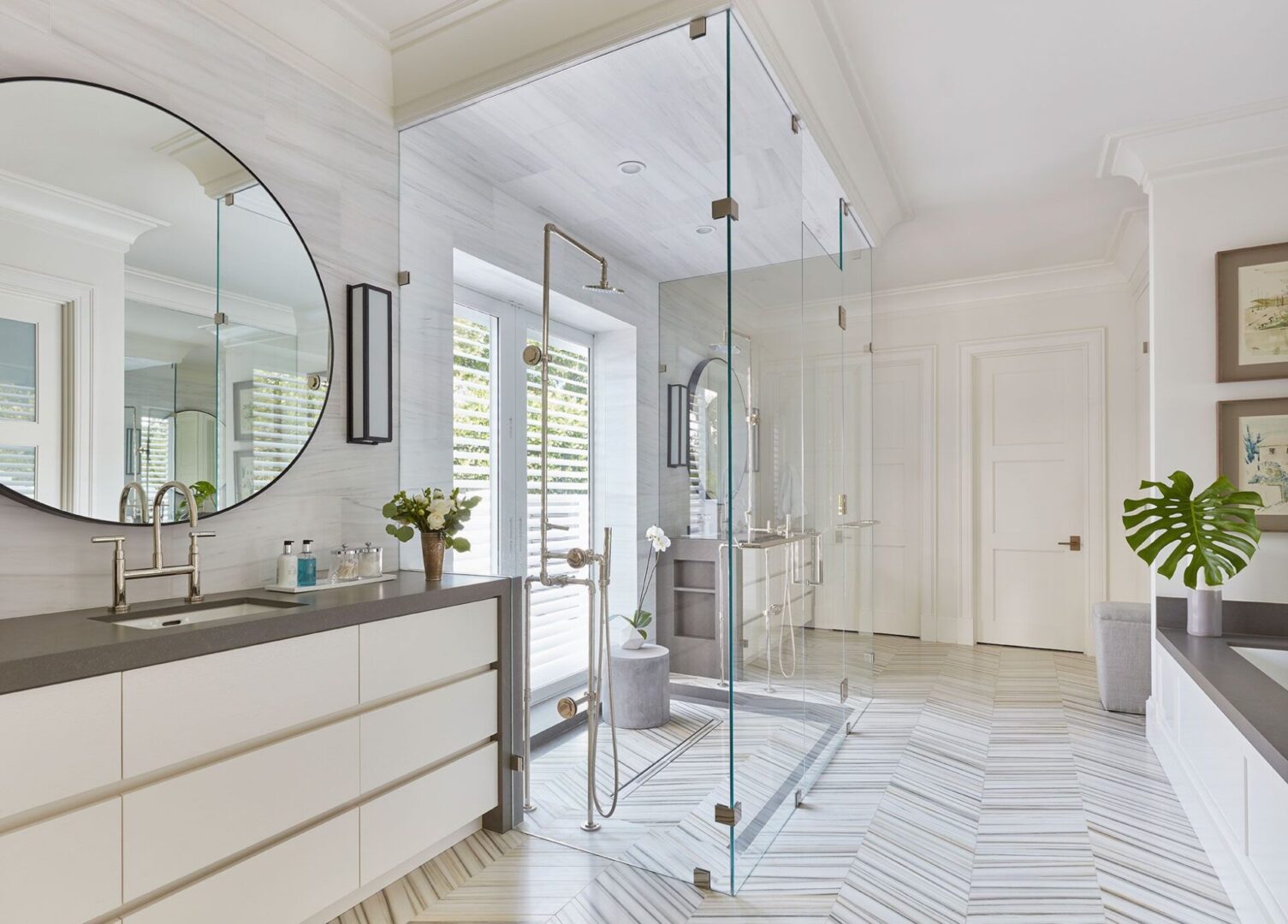 A bathroom with white walls and floors, and a large mirror.
