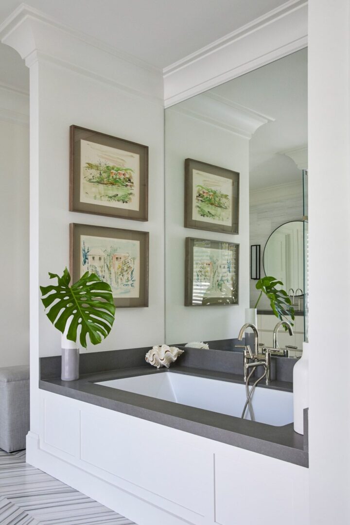 A bathroom with two framed pictures hanging on the wall.