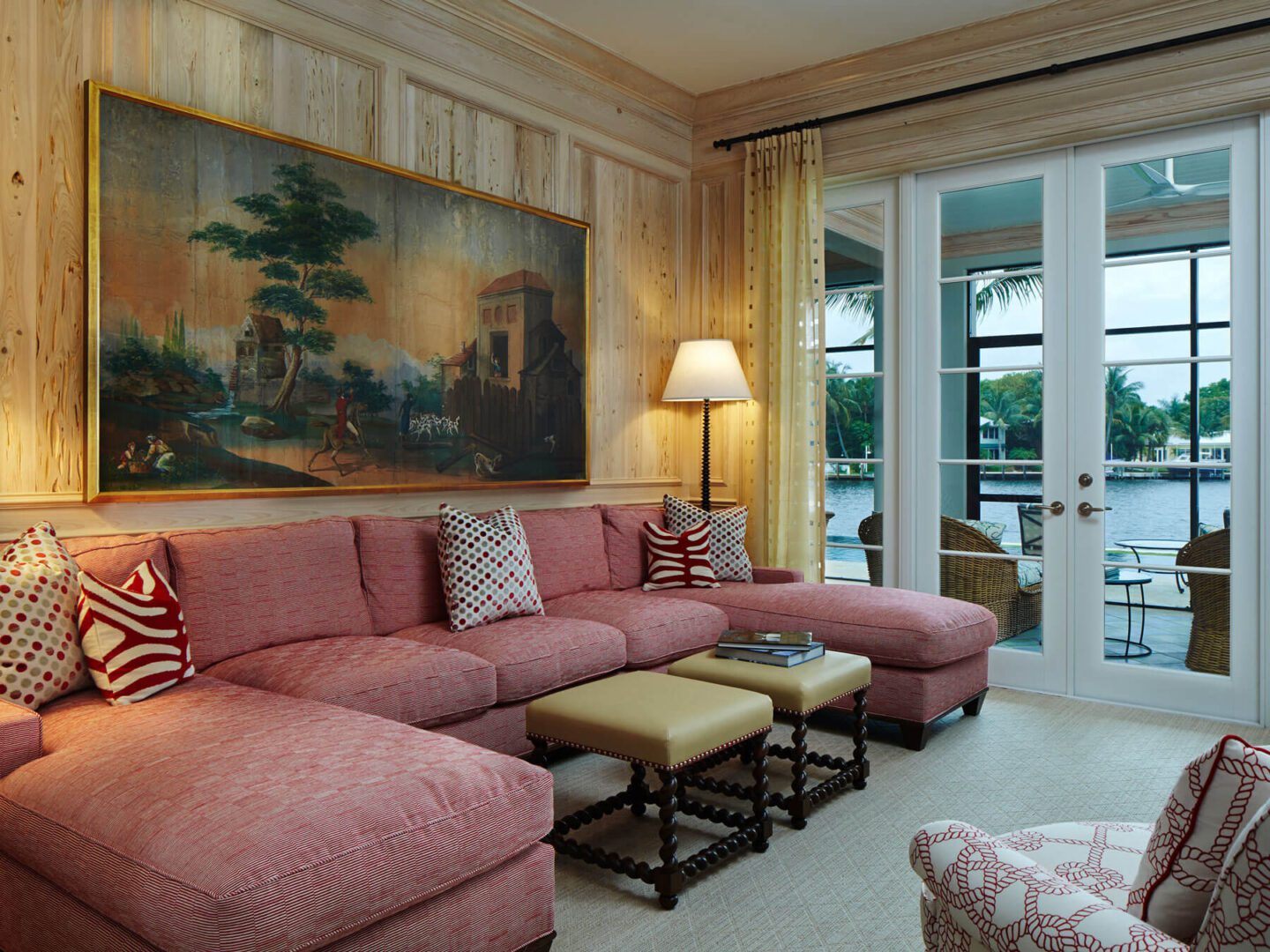 A living room with pink couches and a painting on the wall.