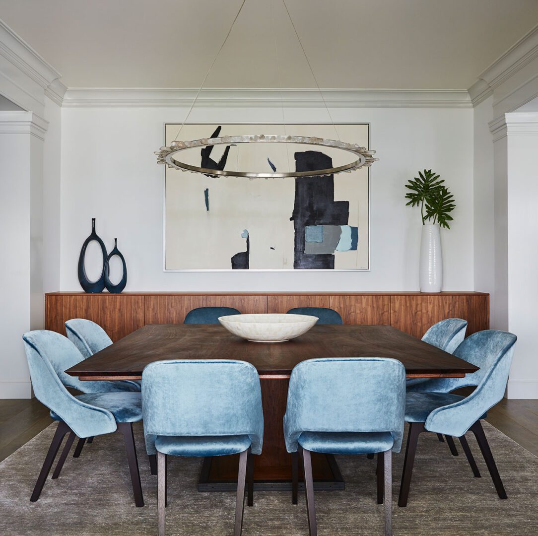 A large square dining table with blue chairs