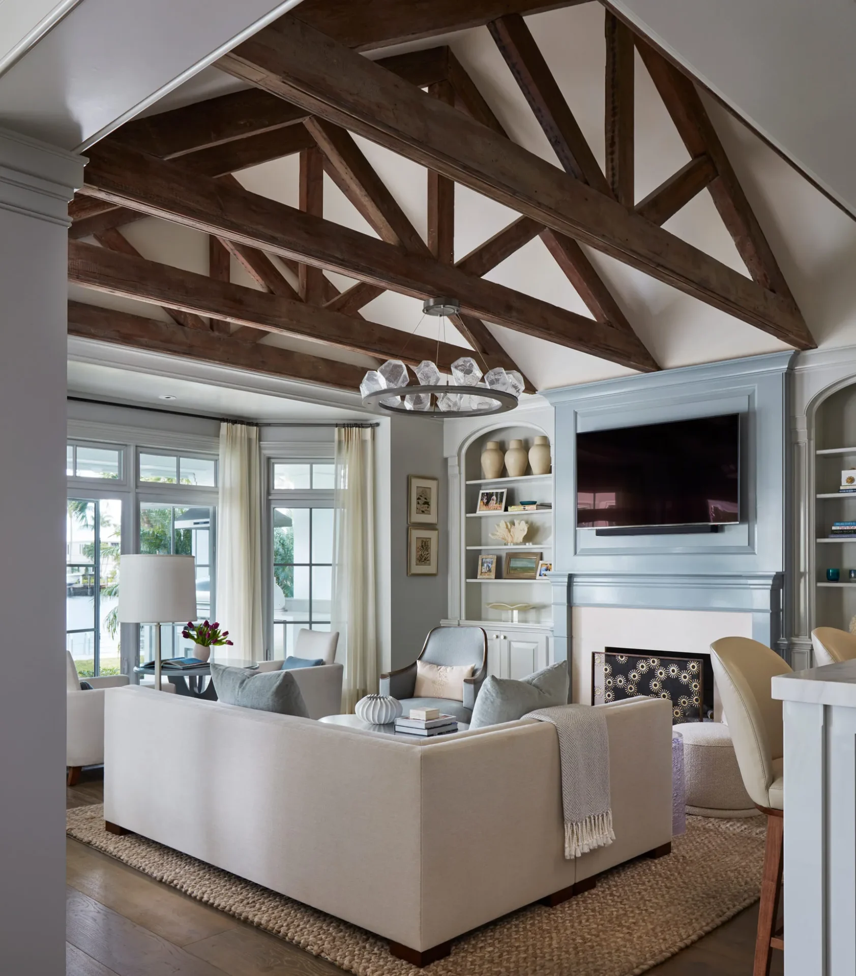 A living room with white furniture and wooden beams.