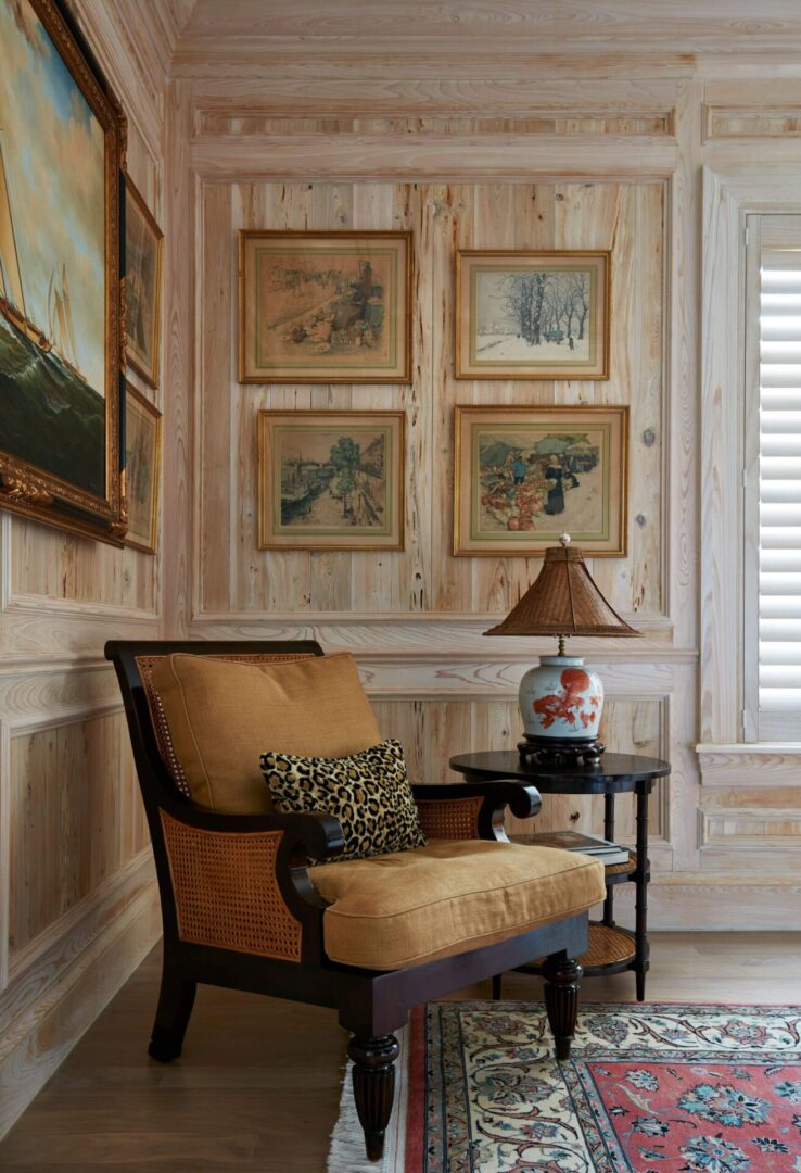 A chair and table in a room with wood paneling.