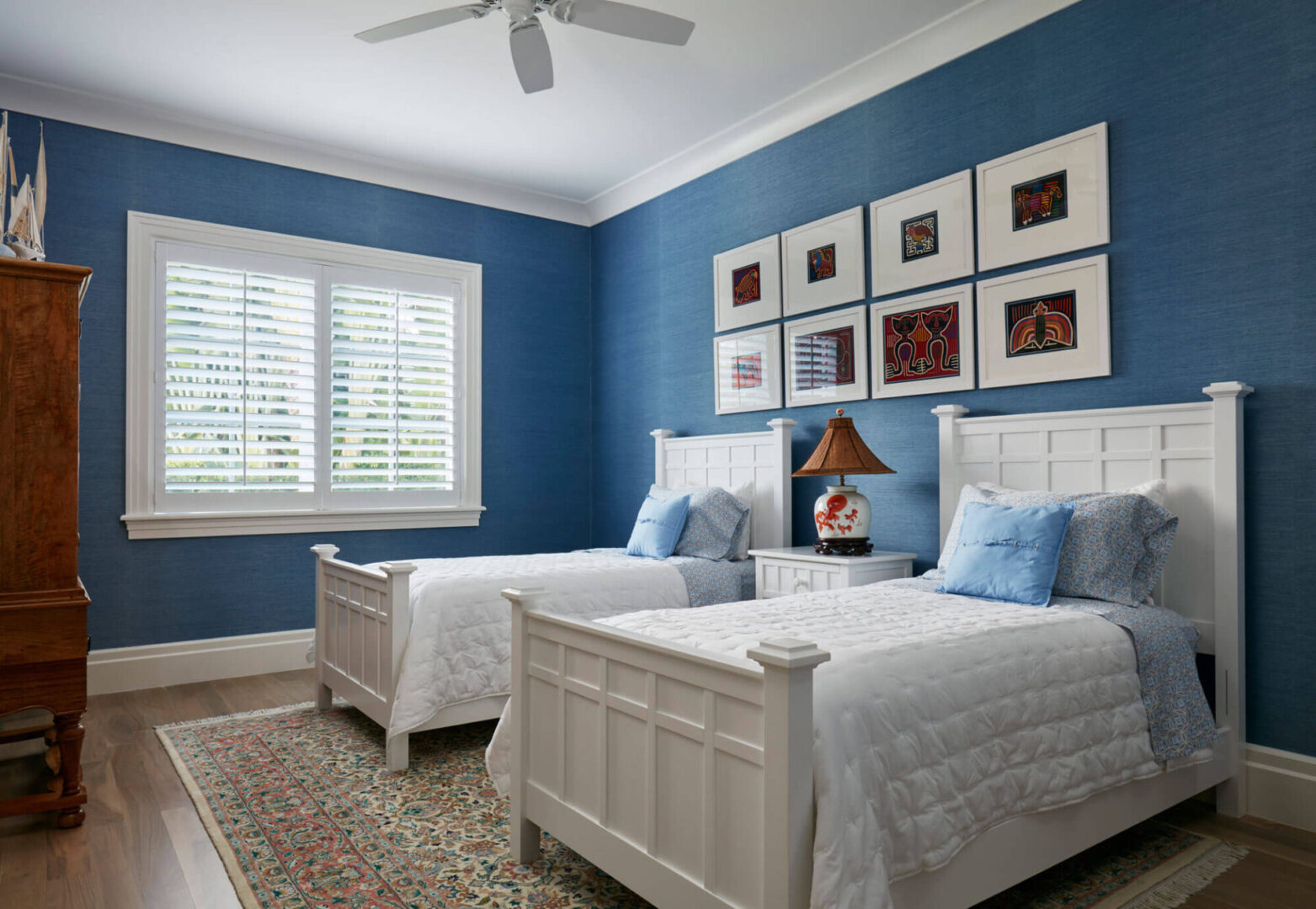 A bedroom with two beds and blue walls