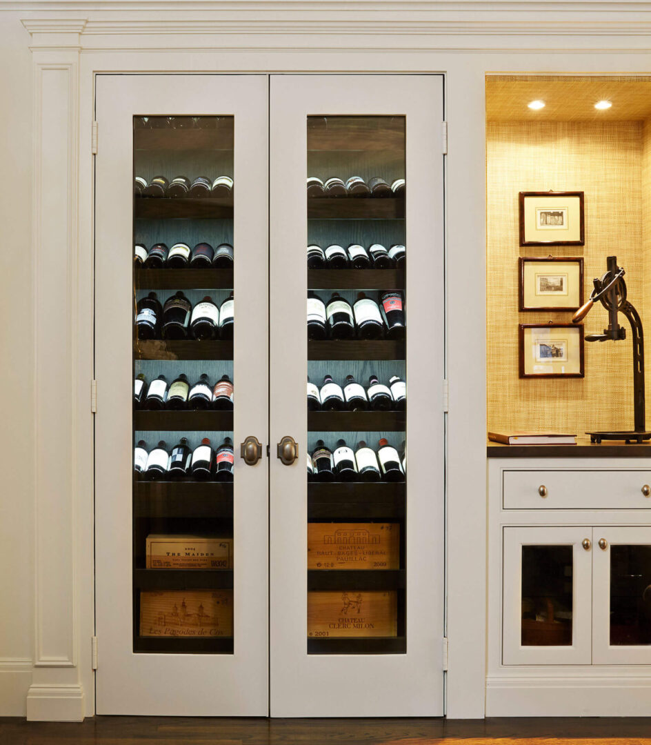 A wine cellar with two doors and shelves filled with bottles.
