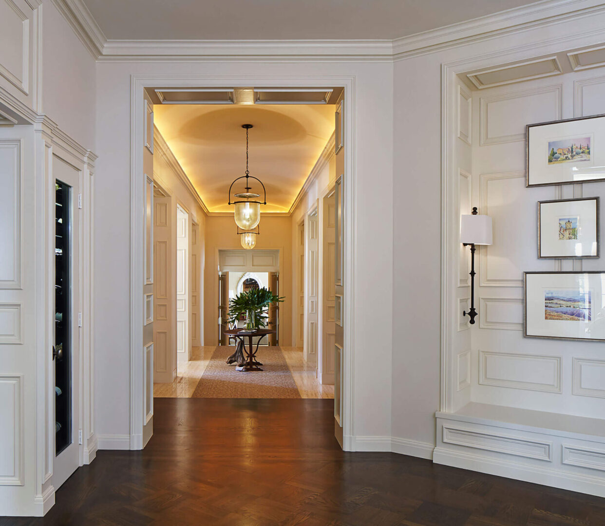 A hallway with white walls and wooden floors.