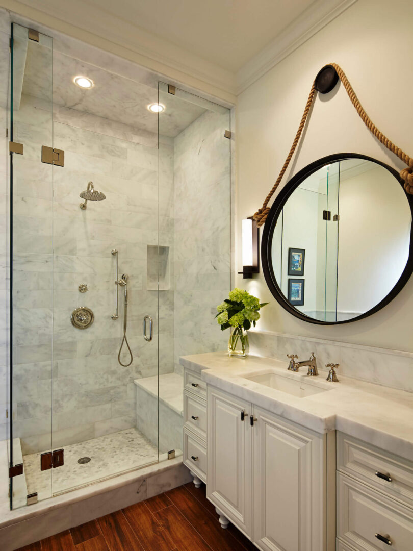 A bathroom with a large mirror and a glass shower.