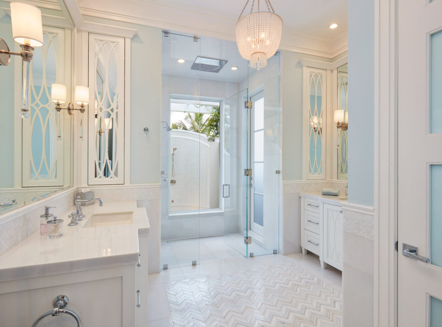 A bathroom with white tile and marble floors.