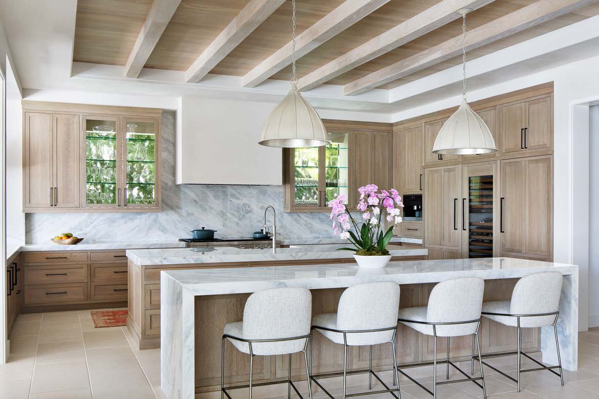A kitchen with white chairs and wooden cabinets