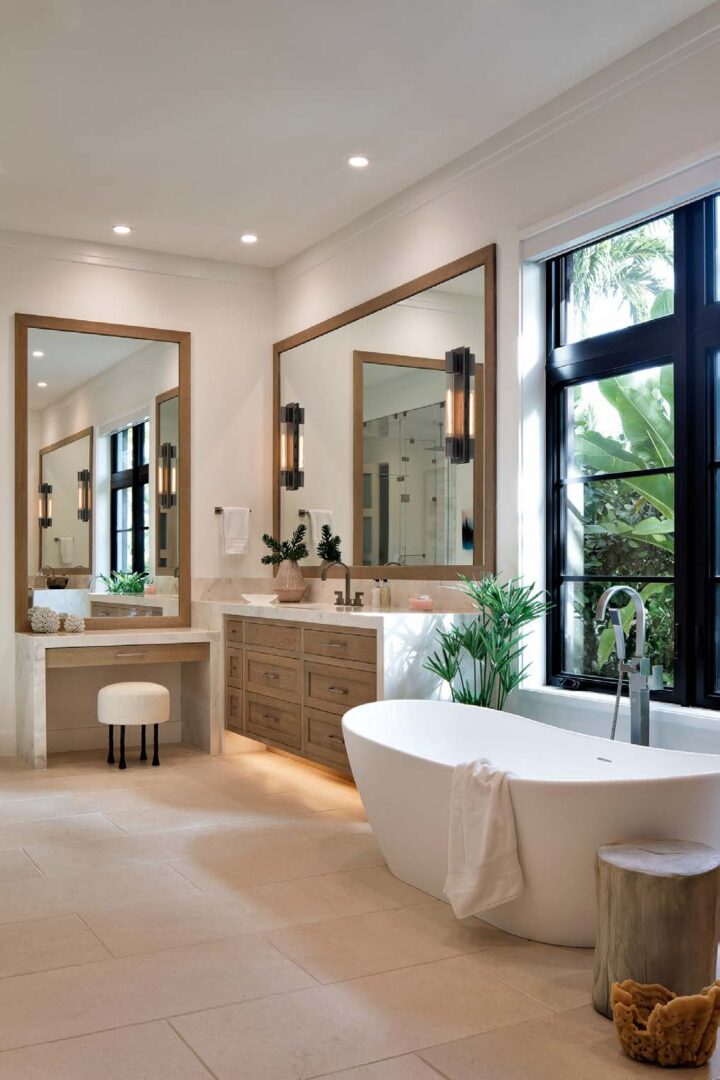 A bathroom with two mirrors and a tub