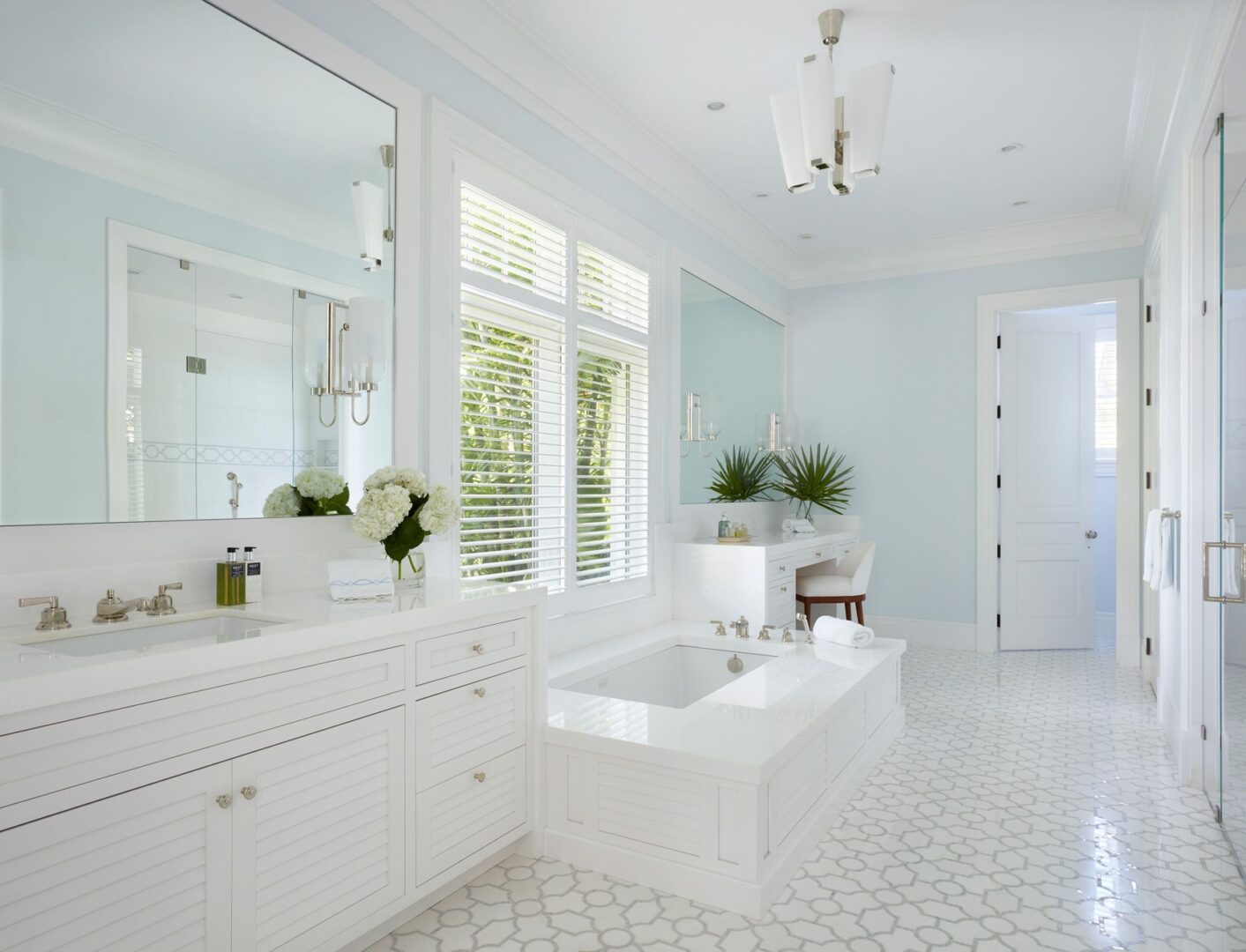 A white bathroom with a large mirror and tub.
