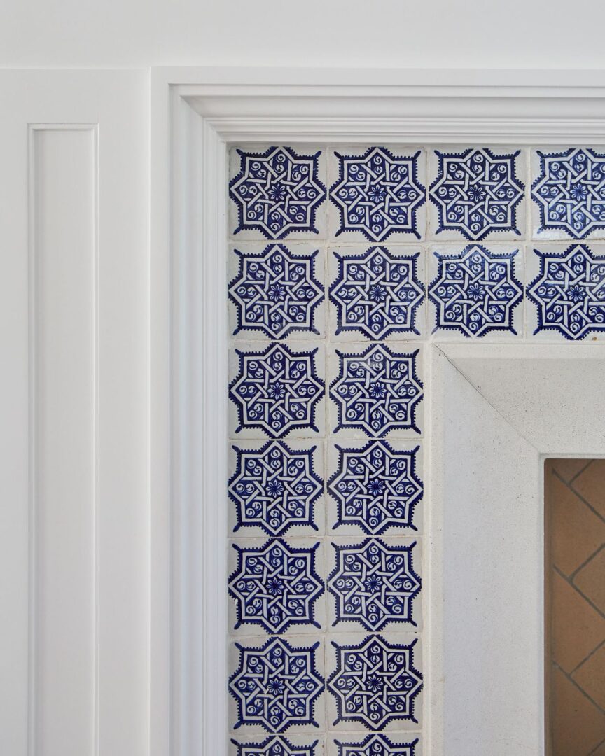 A close up of the wall with blue and white tiles