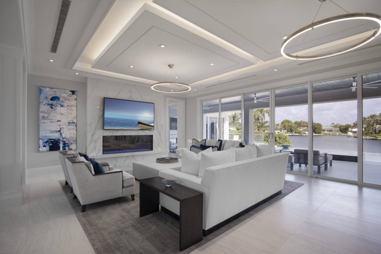 Modern living room with white sofa and water view.