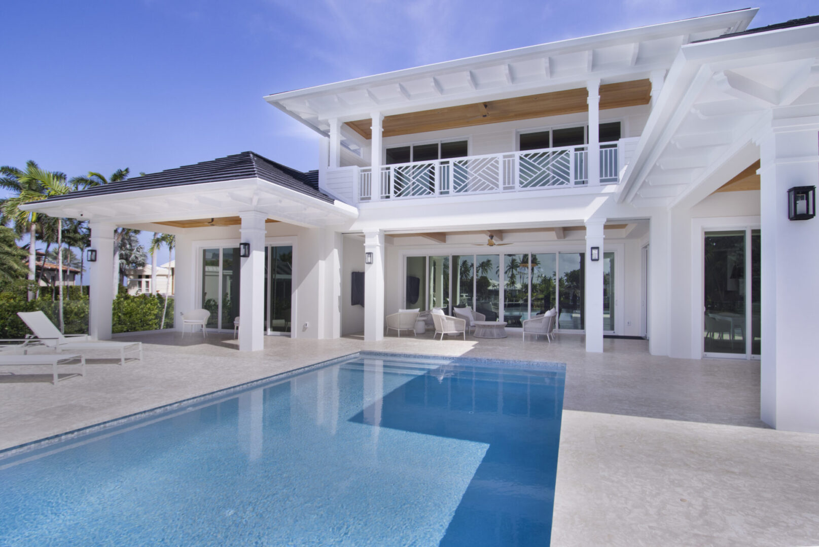 White house with pool and patio.