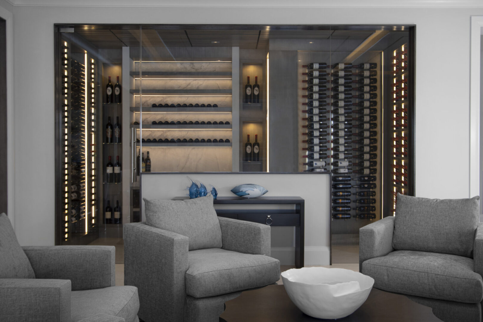 Modern wine cellar with grey armchairs.