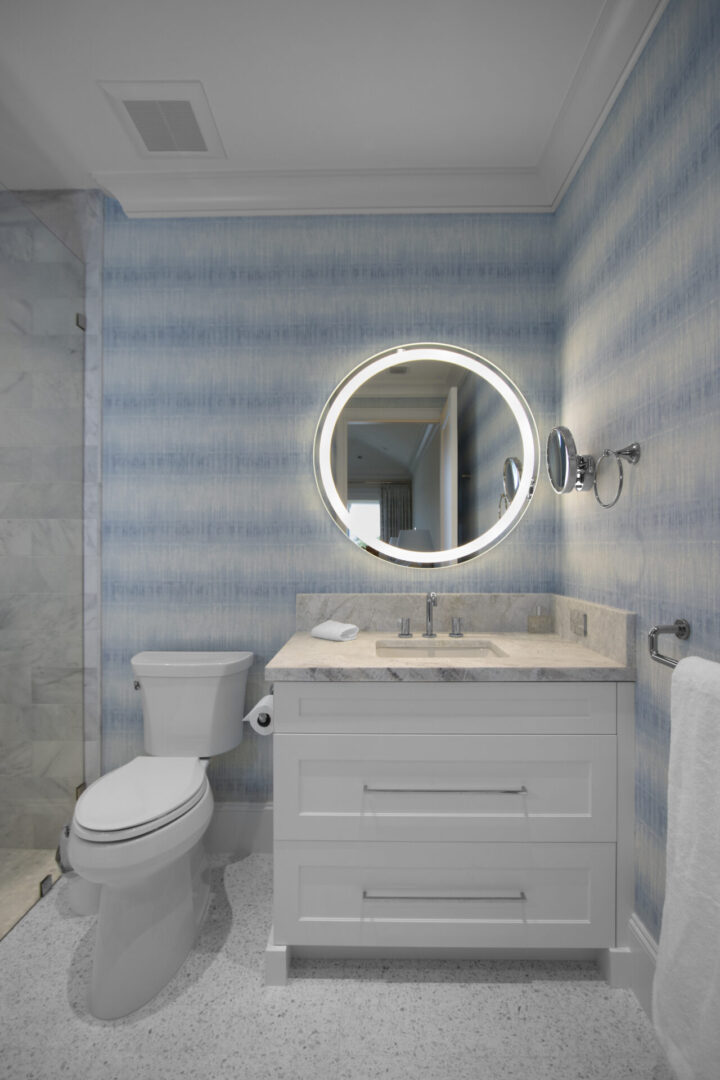 White bathroom with a round mirror.